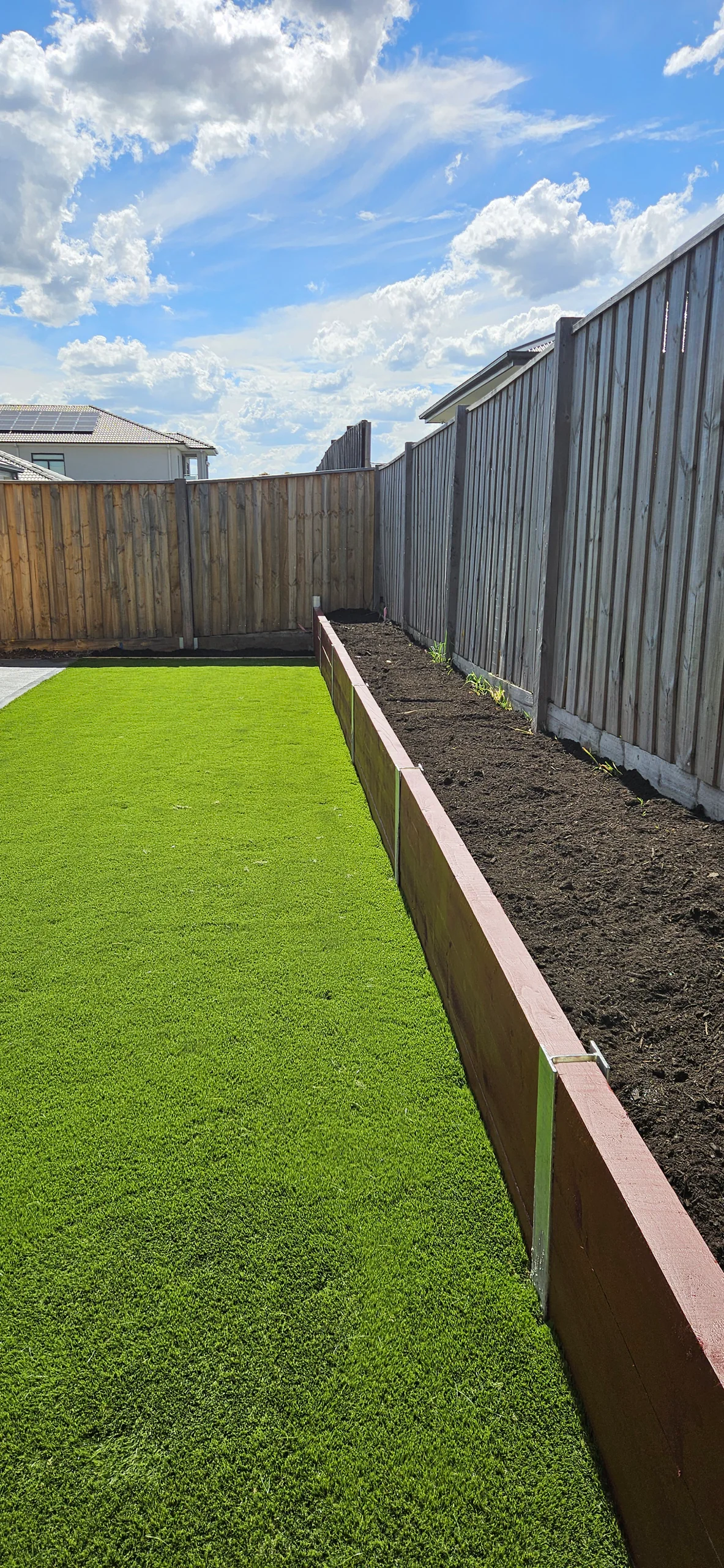 Finished Beveridge backyard with turf and timber-sleeper retaining