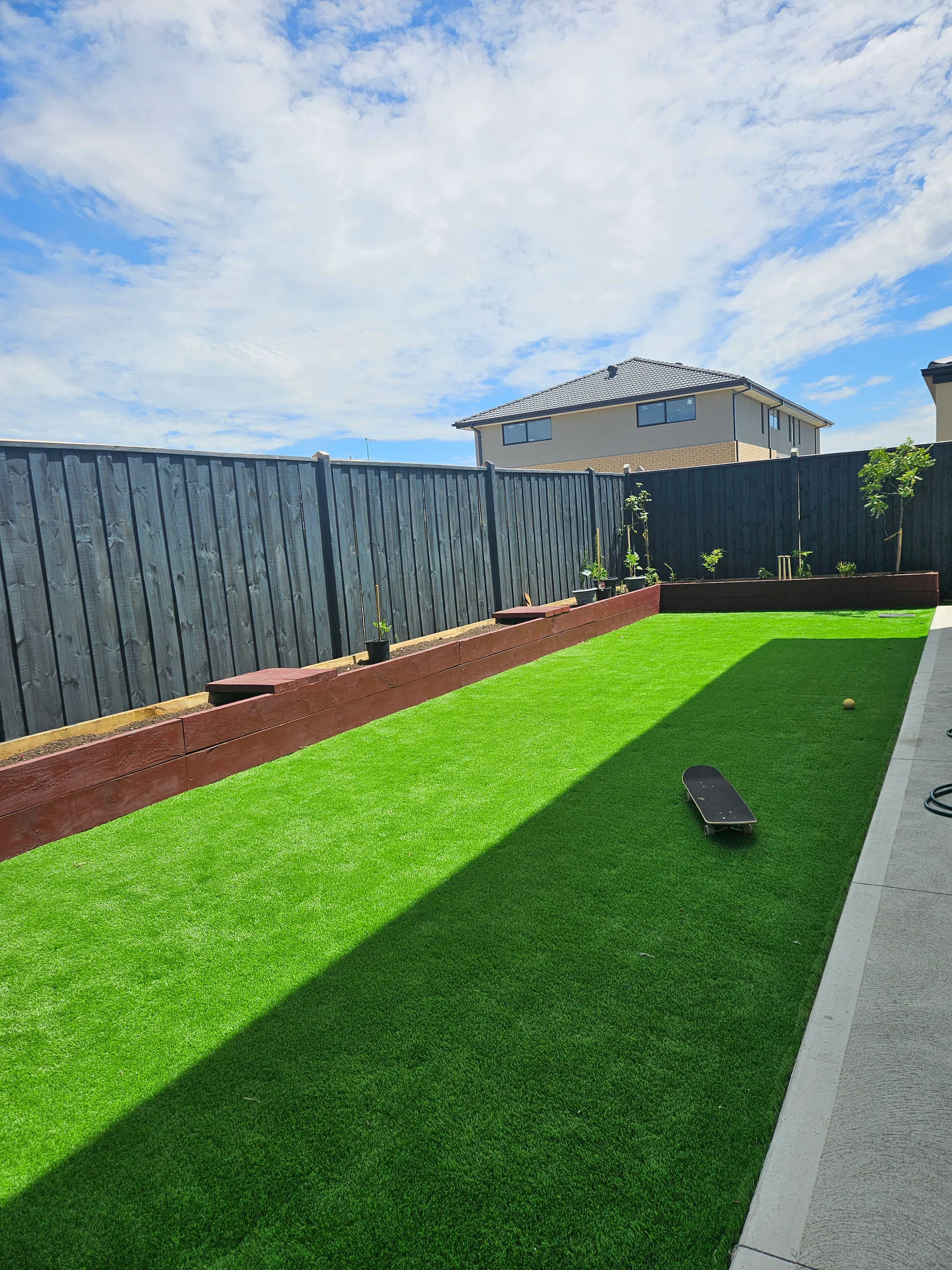 Finished Clyde backyard with artificial turf and landscaping