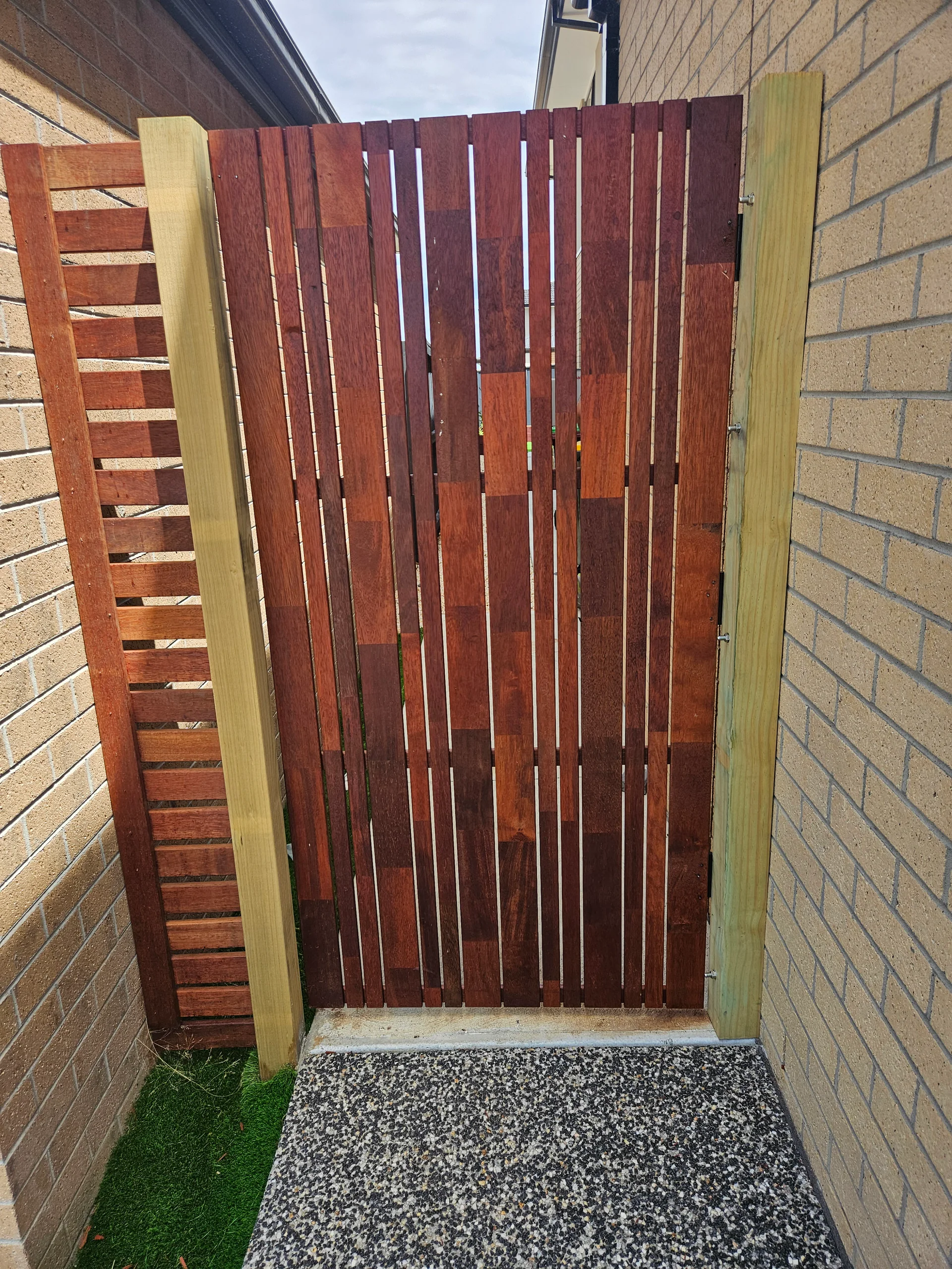 Custom merbau vertical-batten side gate in Berwick