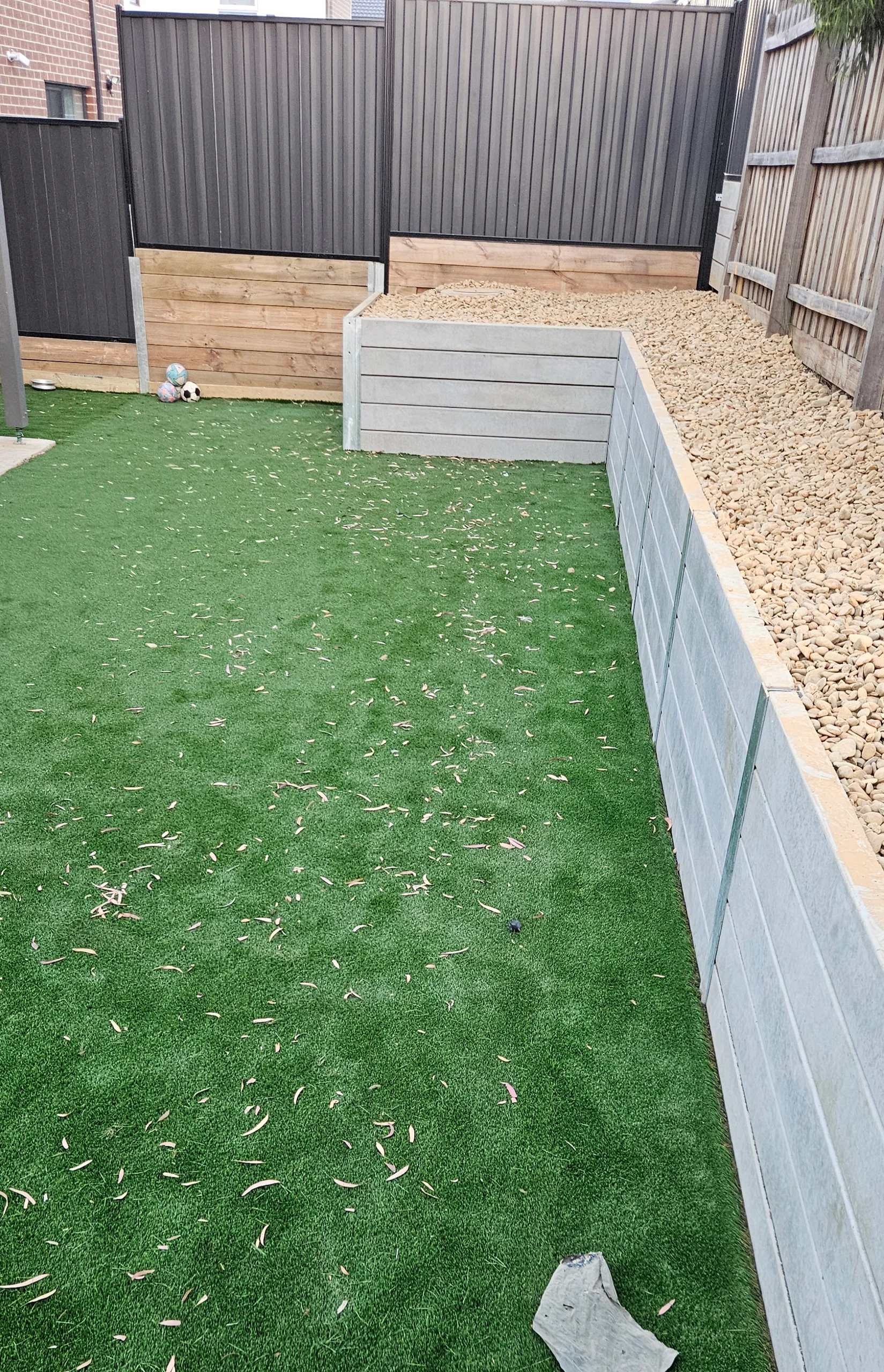 Levelled Mernda backyard with concrete-sleeper retaining wall and turf